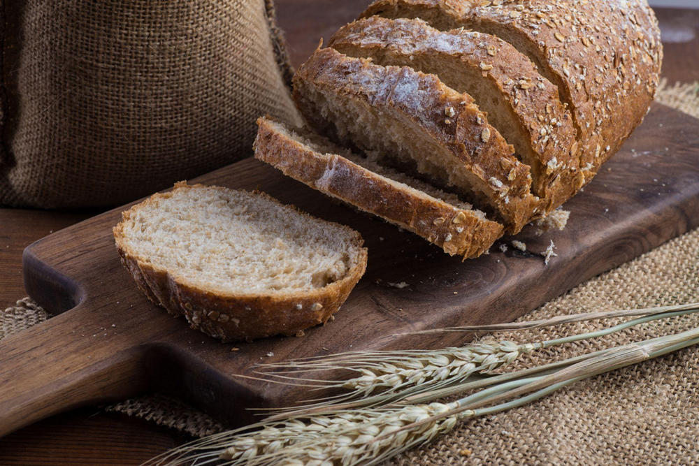 На деревянной доске нарезанные куски ржаного хлеба