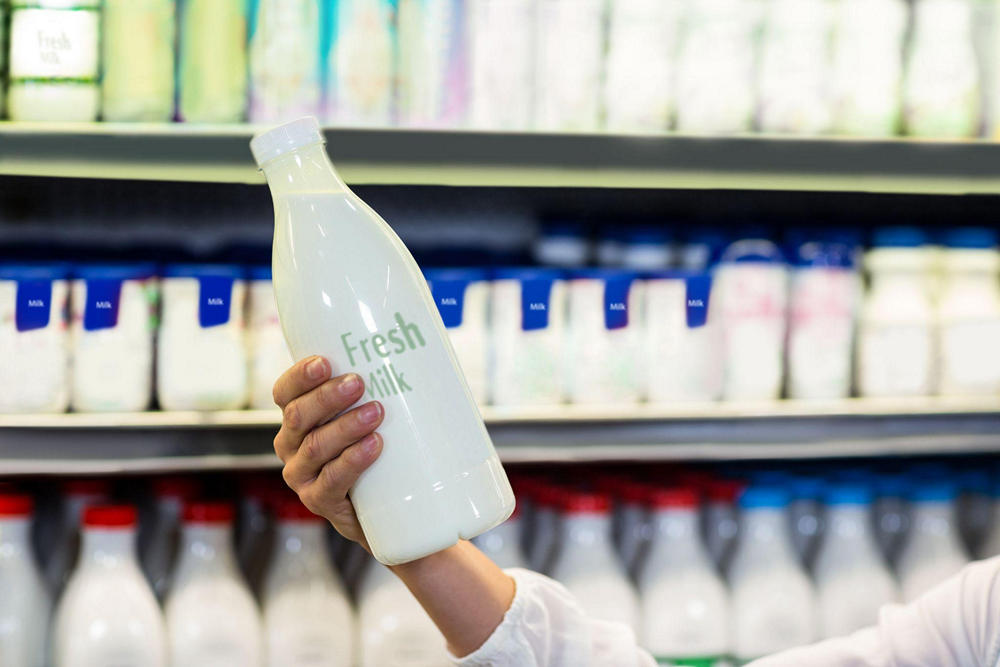 Человек рассматривает бутылку молока