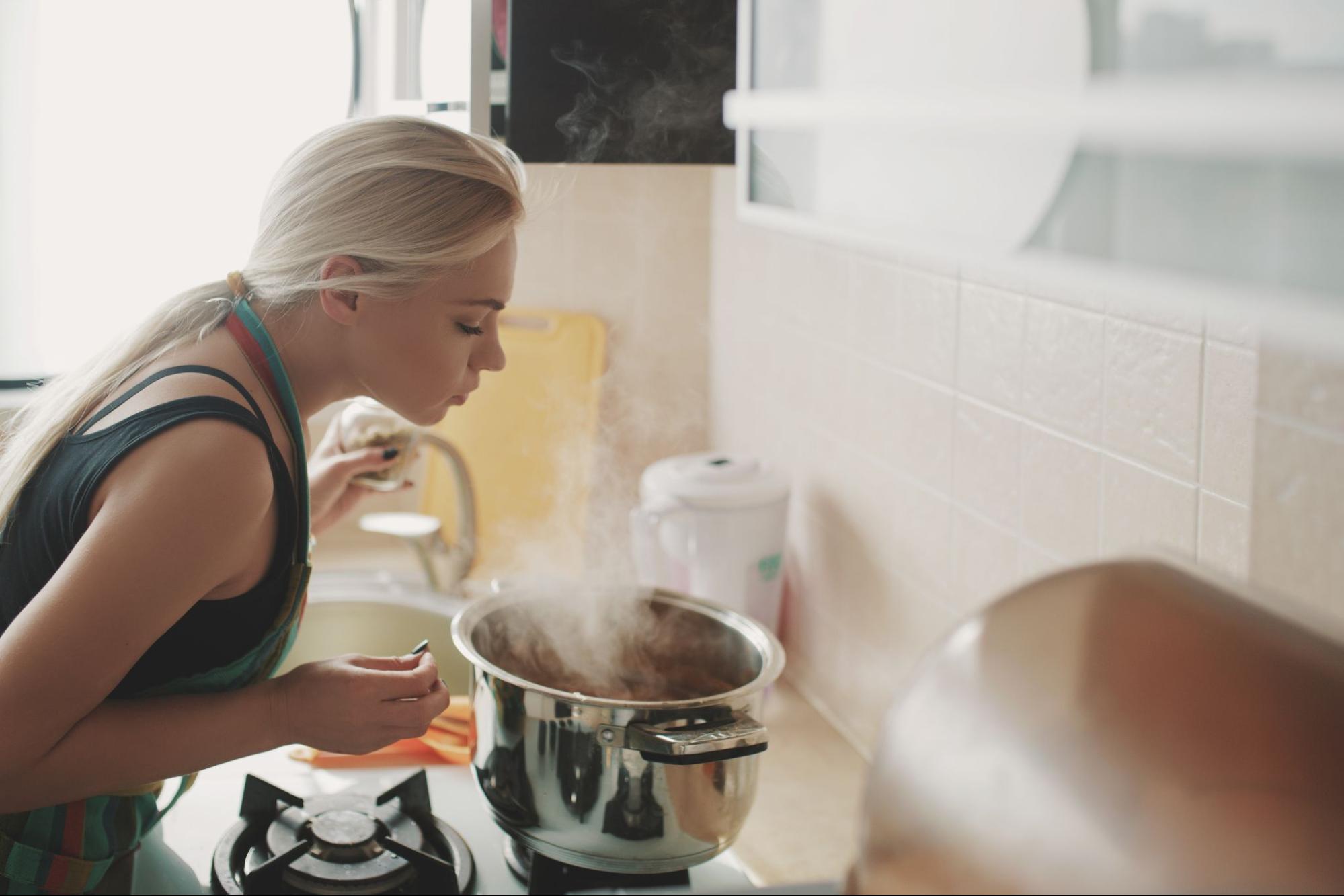 Девушка готовит суп на кухне