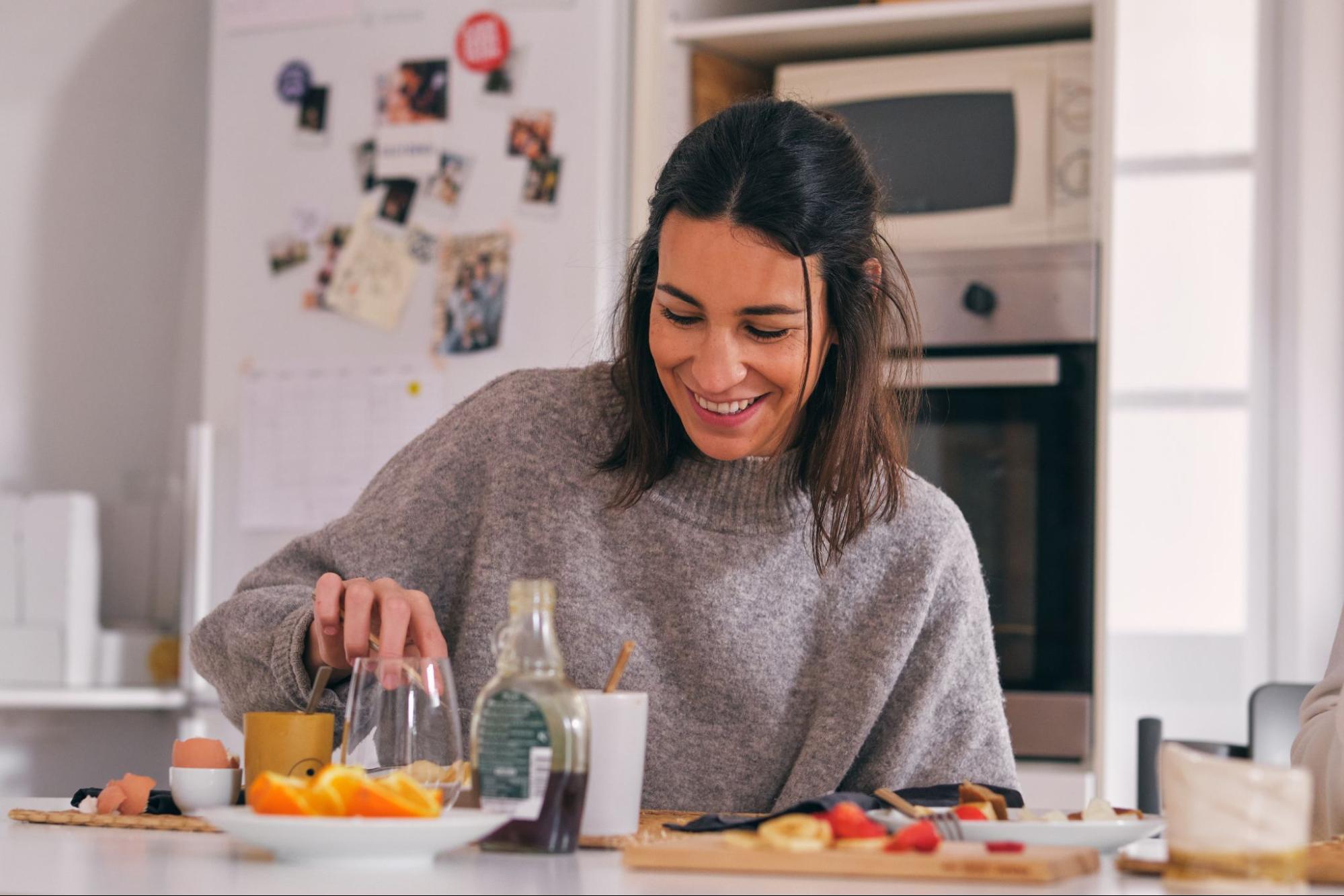 Весёлая девушка кушает за столом